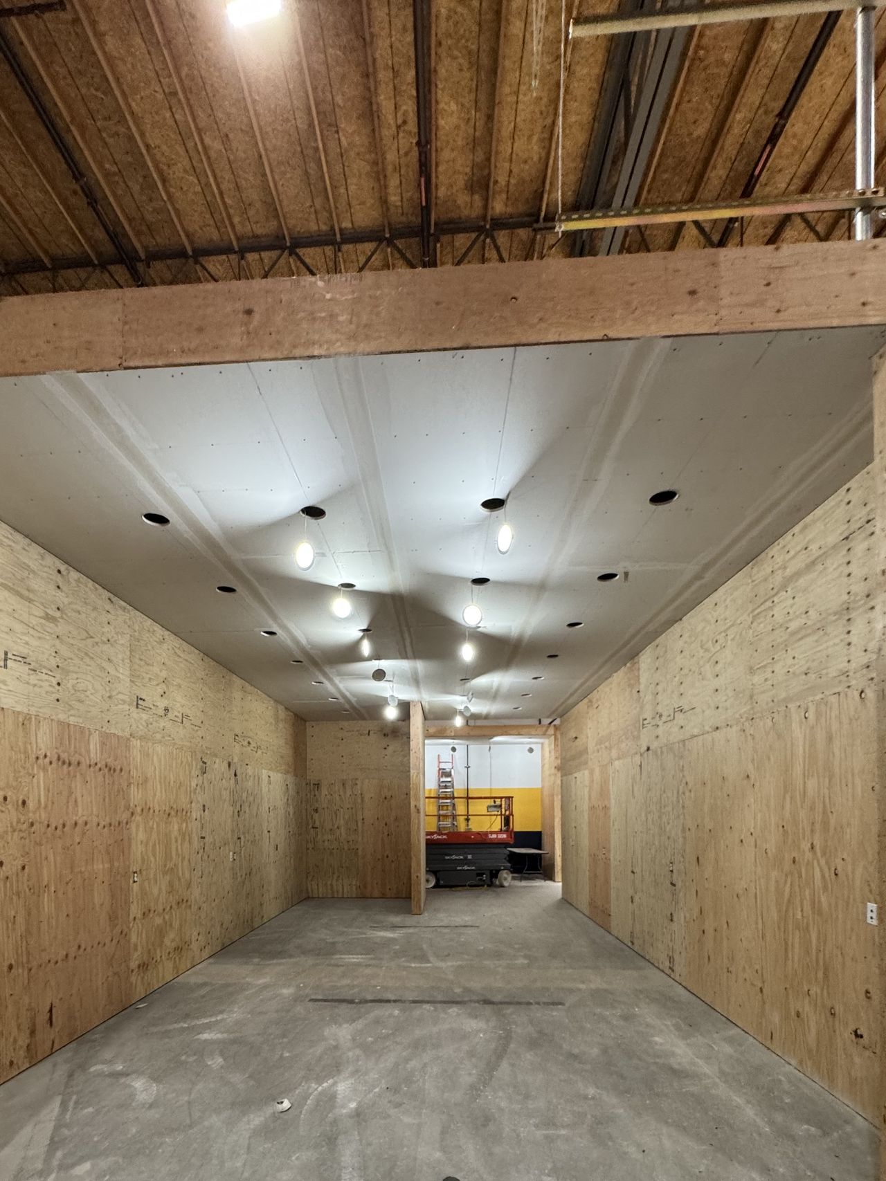 Commercial corridor with plywood on the walls before drywall