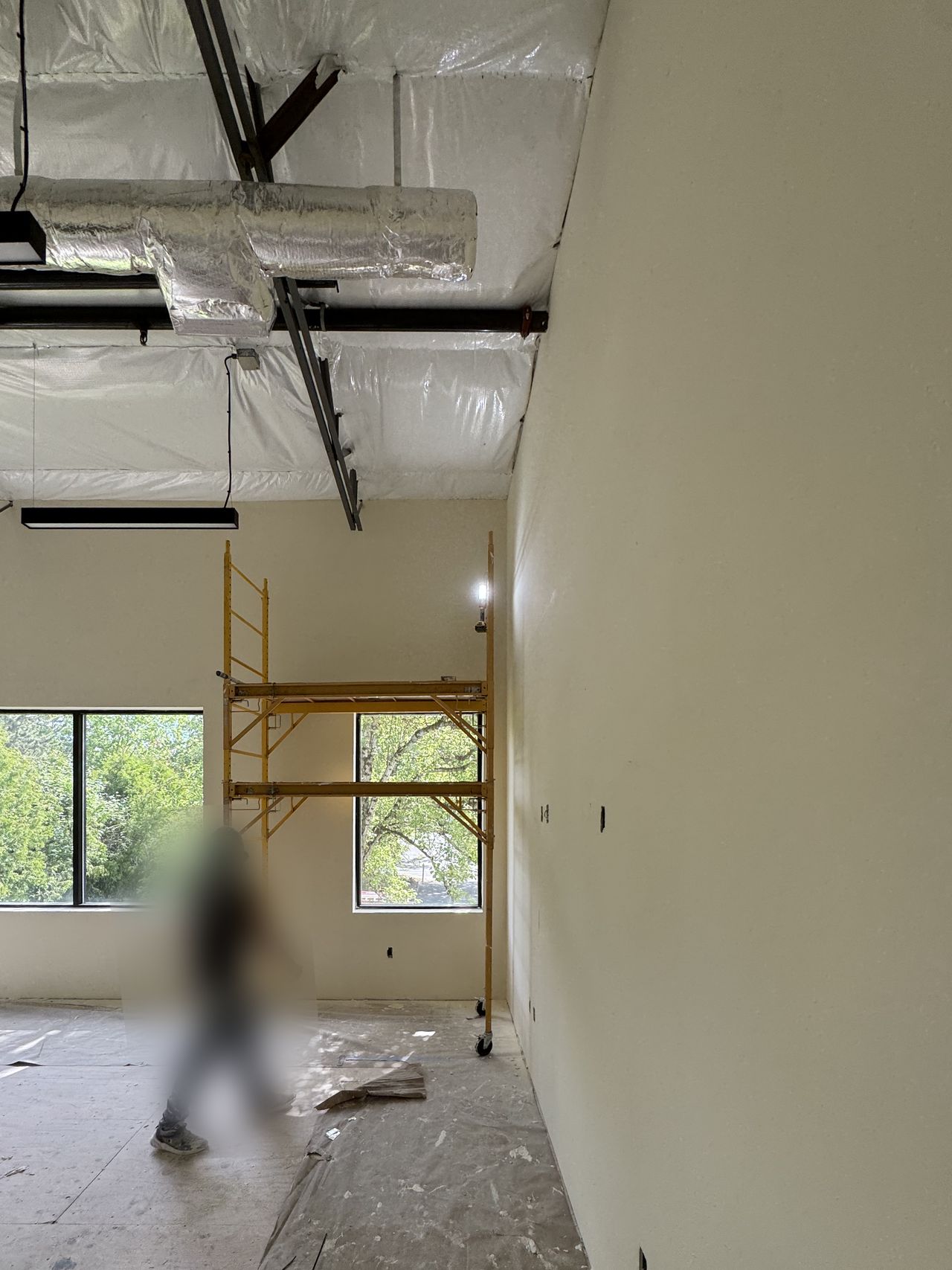 Commercial room with new walls finished and scaffolding set for the high work