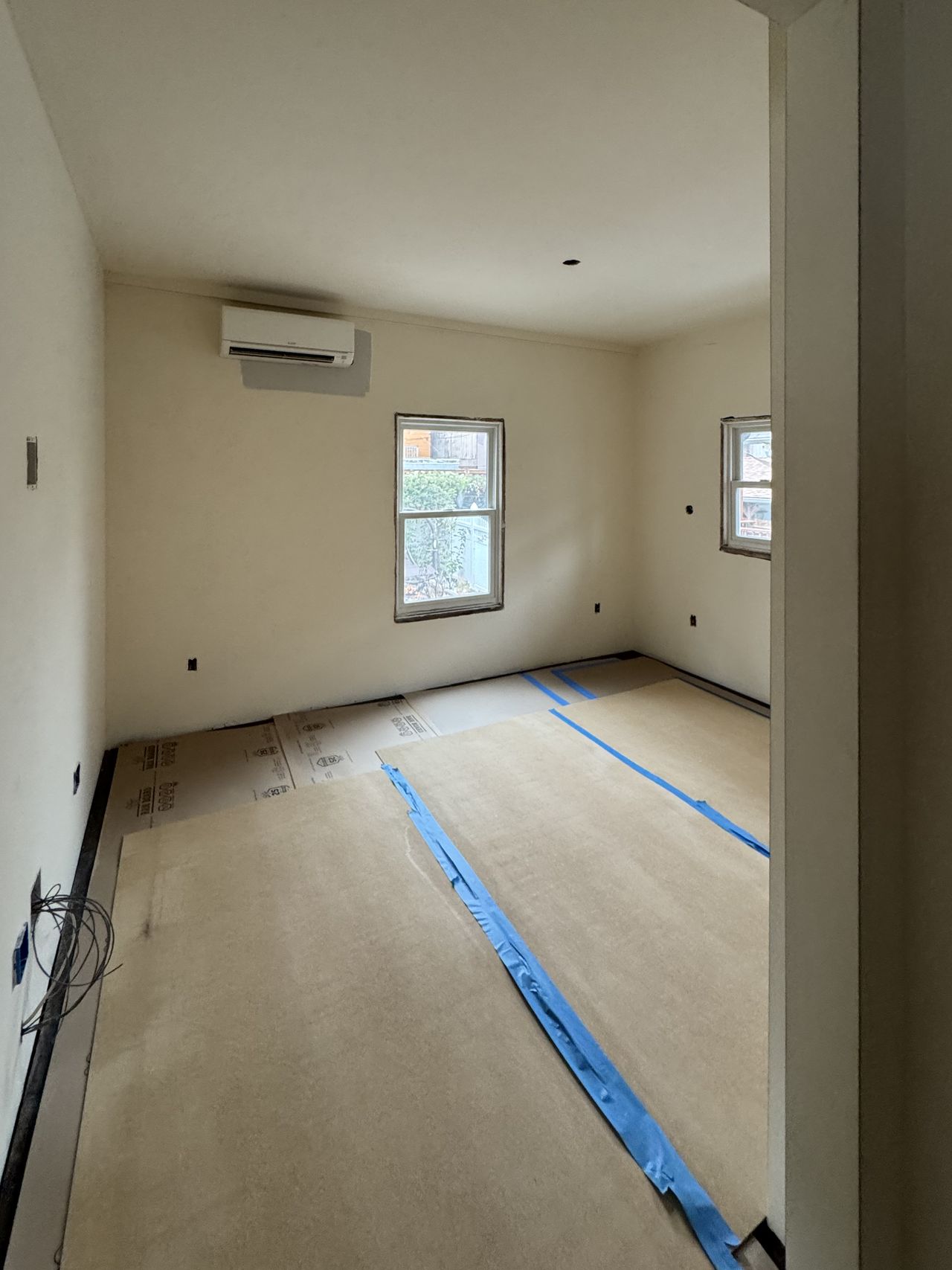 A finished bedroom with smooth walls and ceiling, ready for paint