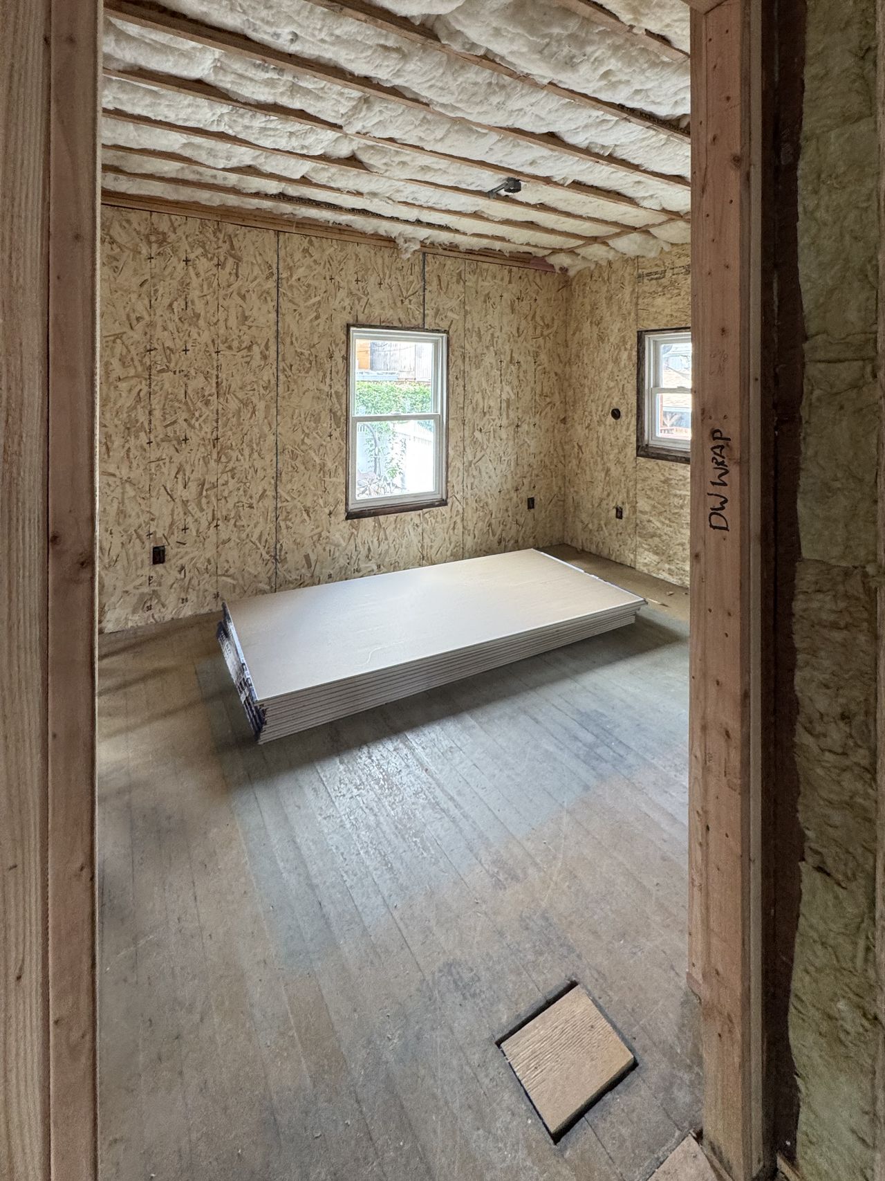 Room in an older house open to the studs, sheathing, and ceiling insulation