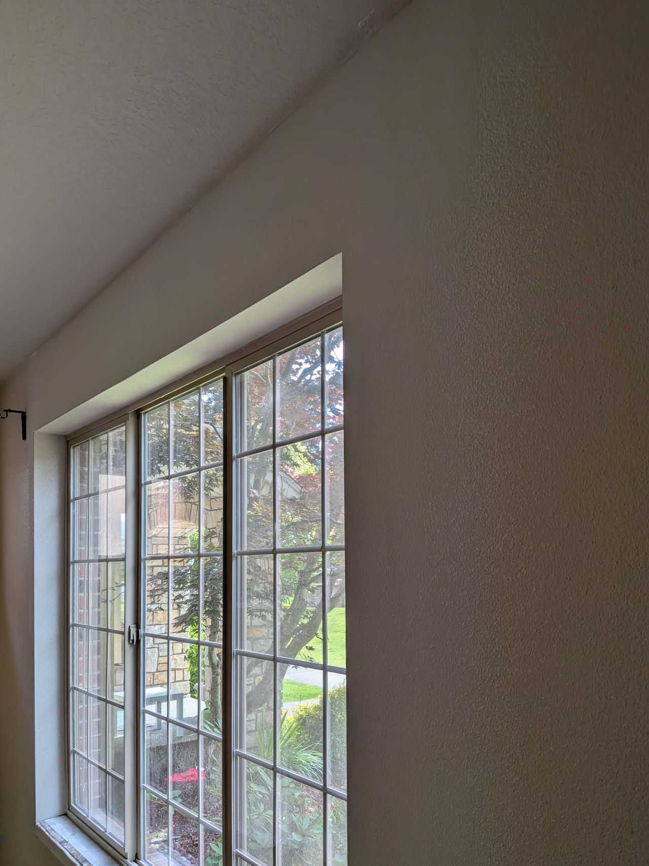 The same window wall closed up, textured, and painted