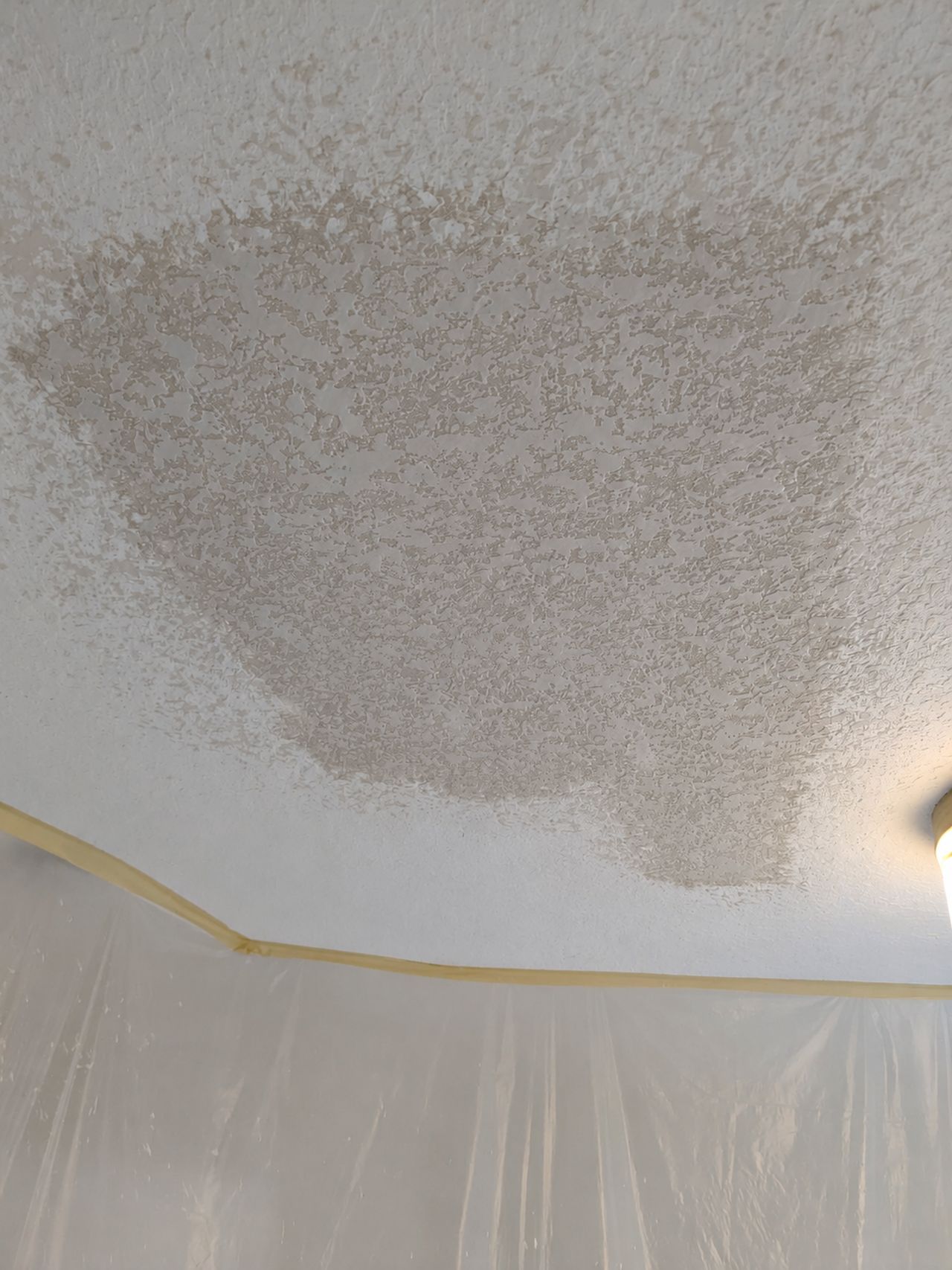The ceiling patch textured to match, shown before paint